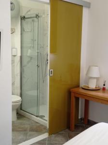 e bagno con doccia, servizi igienici e tavolo. di Appartamento di Giò a Palermo