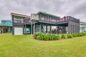 a large house with a deck on top of a yard at Lovely Crystal Beach House with Deck Walk to Ocean! in Crystal Beach