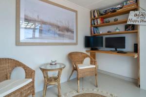 sala de estar con mesa, sillas y TV en Large Private Terrace - North Facing Terrace & BBQ, en Deewhy