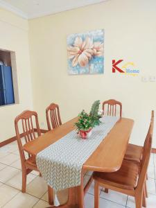 a dining room table with four chairs and a painting at KHome-MarinaCourt-KK CITY CENTRE .3B2R(8Pax) NEW!! in Kota Kinabalu