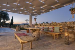 a patio with a table and bench and a stone wall at Louiza - Luxury Stone Villa in Volimes