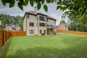 a house with a dog standing in the yard at Spacious Home about 7 Mi to Stone Mountain Park! in Stone Mountain