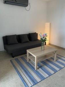 un soggiorno con divano nero e tavolino da caffè di Cozy apartment on the beach a Haifa