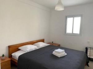 una camera da letto con un letto con lenzuola bianche e una finestra di Cozy apartment on the beach a Haifa