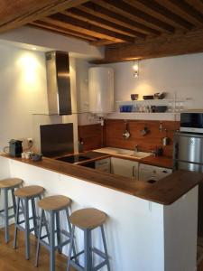 a kitchen with a counter with stools around it at Le Mercière - Joli T2 au coeur de Lyon presquîle in Lyon