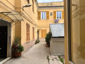 une allée vide avec des plantes en pot sur un bâtiment dans l'établissement Appartamento Grandis, à Gênes