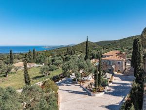 an aerial view of a villa with trees and the ocean at Louiza - Luxury Stone Villa in Volimes