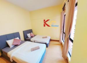 a room with two beds and a k home sign on the wall at KHome-MarinaCourt-KK CITY CENTRE .3B2R(8Pax) NEW!! in Kota Kinabalu