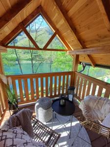 a screened in porch with a table and chairs at Drinska Dama in Bajina Bašta
