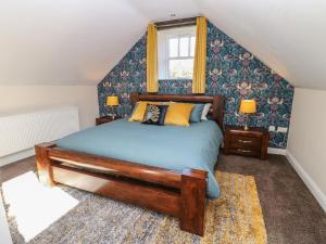 1 dormitorio con cama de madera y ventana en The Dairy en Bishop Auckland