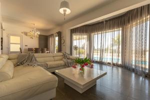 a living room with a couch and a table at Amazing Villa with panoramic sea view in Paphos City