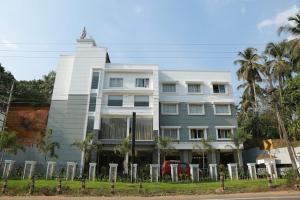 a white building with a statue on top of it at HOTEL SKY PARADISE in Iritti +4 photos