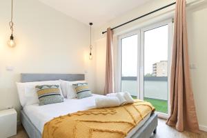 een slaapkamer met een bed en een groot raam bij Sé Apartamentos - Largo da Estação Apartments in Braga