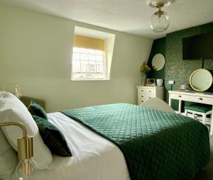 1 dormitorio con 1 cama con edredón verde y blanco en The Wadham, en Weymouth