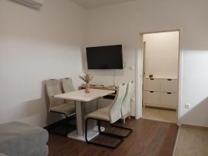 um quarto com uma mesa e cadeiras e uma televisão em Apartment Lungomare em Umag
