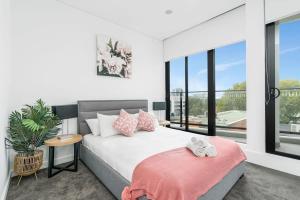 Een bed of bedden in een kamer bij Sparkling New Apartment - Wollongong