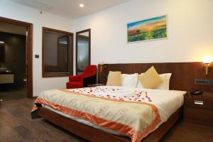 a bedroom with a large bed with a red chair at HOTEL SKY PARADISE in Iritti