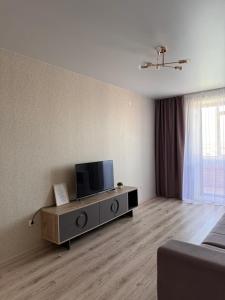 a living room with a flat screen tv on a entertainment center at 2-комнатная квартира посуточно, почасово in Kostanay