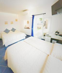 a bedroom with two beds and a desk in it at B&B La Danza del Mare in Anacapri +28 photos