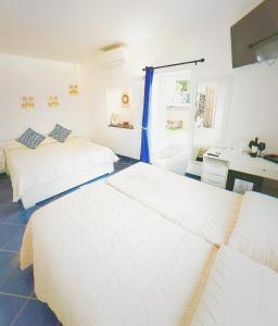 a bedroom with two beds and a desk in it at B&B La Danza del Mare in Anacapri