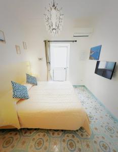 un grande letto in una stanza con lampadario a braccio di B&B La Danza del Mare ad Anacapri