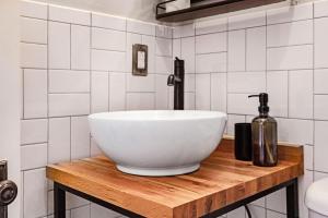 a bathroom with a white bowl sink on a wooden counter at Roami at Tower Hotel in Miami