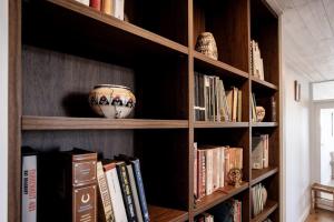a book shelf with books and a vase on it at Spectacular Ocean View Apartment North Wollongong in Wollongong