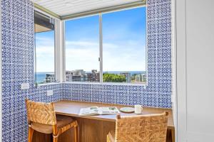 a room with a table and a window with a view at Spectacular Ocean View Apartment North Wollongong in Wollongong