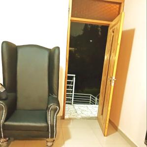 a green chair sitting next to an open door at BEST APARTMENTS in Mbabane