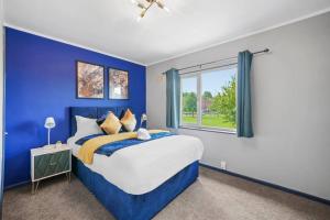een blauwe slaapkamer met een bed en een raam bij Spacious Luxury Garden House Free Parking in Bristol