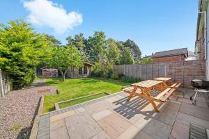 a patio with a wooden picnic table in a backyard at Spacious Luxury Garden House Free Parking in Bristol