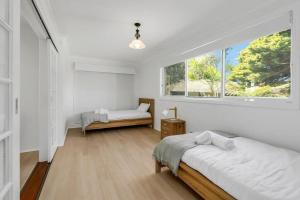 a bedroom with two beds and a window at Lakeside Family Oasis - Oak Flats in Albion Park