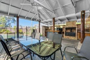 a patio with a table and chairs and a grill at Lakeside Family Oasis - Oak Flats in Albion Park