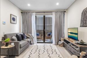 ein Wohnzimmer mit einem Sofa und einem TV in der Unterkunft Hidden Gem on Loftus in Wollongong
