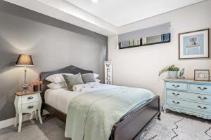 ein Schlafzimmer mit einem Bett und eine Kommode mit einer Lampe in der Unterkunft Hidden Gem on Loftus in Wollongong