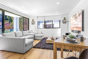 a living room with a couch and a table at Scenic Wollongong Gem - City Location with Rooftop in Wollongong