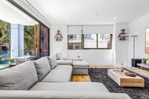 a living room with a couch and a table at Scenic Wollongong Gem - City Location with Rooftop in Wollongong