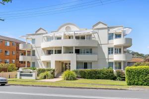 a white building on the side of a street at Seashells Sweet Retreat - Luxury apartment in Nelson Bay
