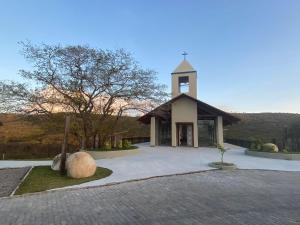 a church with a clock tower in a driveway at Flat 1218, no residencial monte castelo in Bezerros