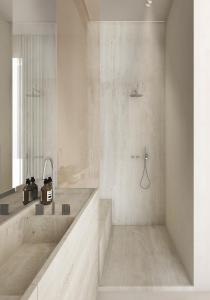 een witte badkamer met een bad en een wastafel bij Hotel Liautaud in Cassis