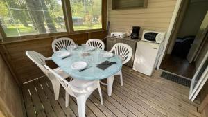 a table and chairs on a porch with a kitchen at Camping en Ardeche Le Lion in Bourg-Saint-Andéol