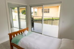 sypialnia z łóżkiem i dużym oknem w obiekcie Green Point Tranquillity w mieście Green Point
