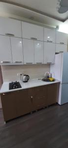 - une cuisine avec des placards blancs et un évier dans l'établissement Apartment House for Rent, à Koutaïssi