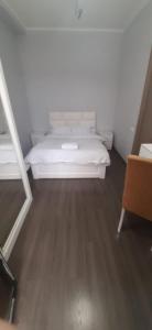 - un lit blanc dans une chambre dotée de parquet dans l'établissement Apartment House for Rent, à Koutaïssi