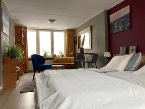 Una habitación de hotel con una cama grande y un escritorio. en PuraVida, en Westkapelle