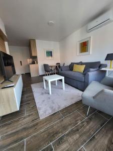 a living room with a blue couch and a table at Apartman J72 in Ostrovo