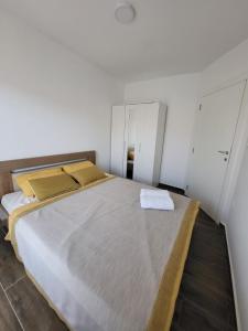 a bedroom with a large bed with two white cabinets at Apartman J72 in Ostrovo