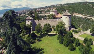 Dj apartment Kostrena في Šodići: اطلالة جوية على قلعة على تلة