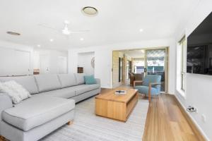 sala de estar con sofá y mesa de centro en Seaside Family Oasis - Anna Bay NSW, en Anna Bay