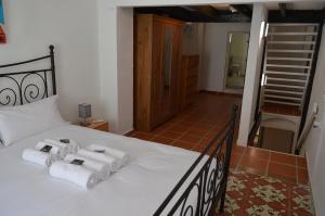 Riola的住宿－Casa del riu.，一间卧室配有一张床,上面有四条毛巾